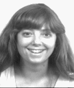 A woman with bangs beaming into the camera.
